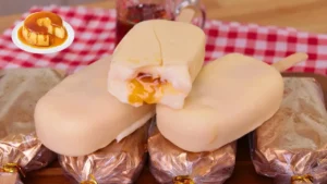 Picolé Gourmet Recheado de Pudim com Casquinha de Chocolate Branco